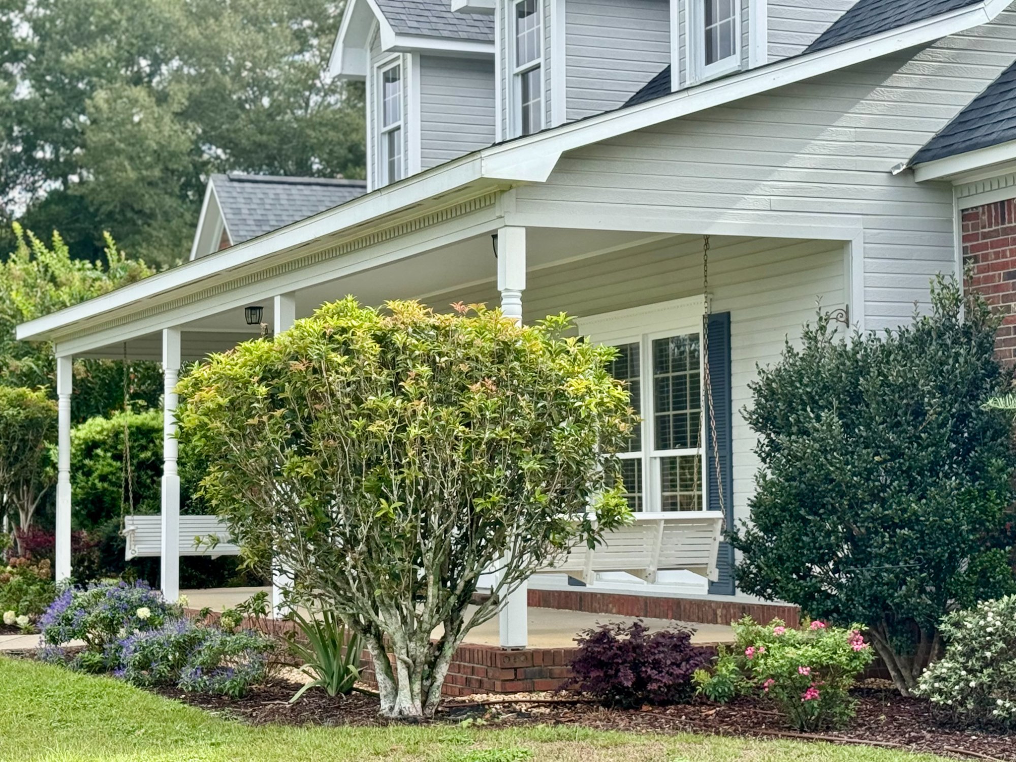 Front porch with swings and landscaping